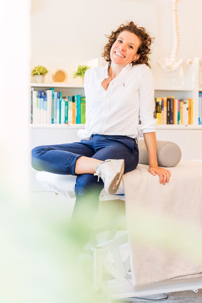 Sophia smiling, sitting on a massage table
